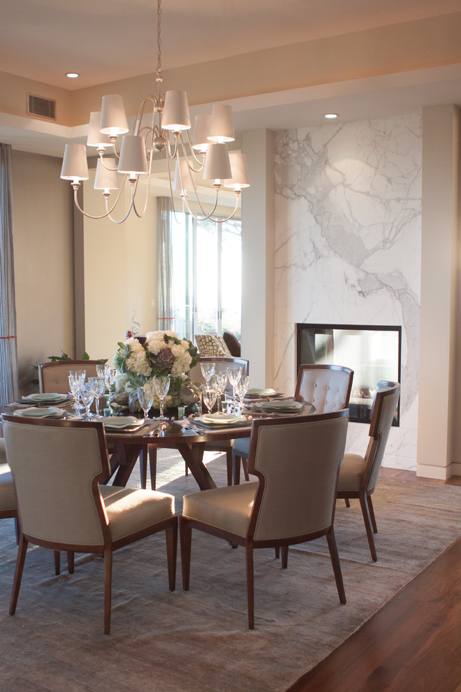 Inspiration for a large contemporary separate dining room in Los Angeles with beige walls, a two-sided fireplace, a stone fireplace surround and dark hardwood floors.
