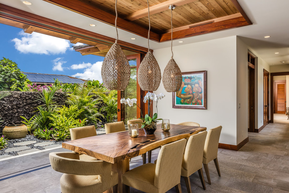 Design ideas for a tropical dining room in Hawaii with white walls and grey floor.