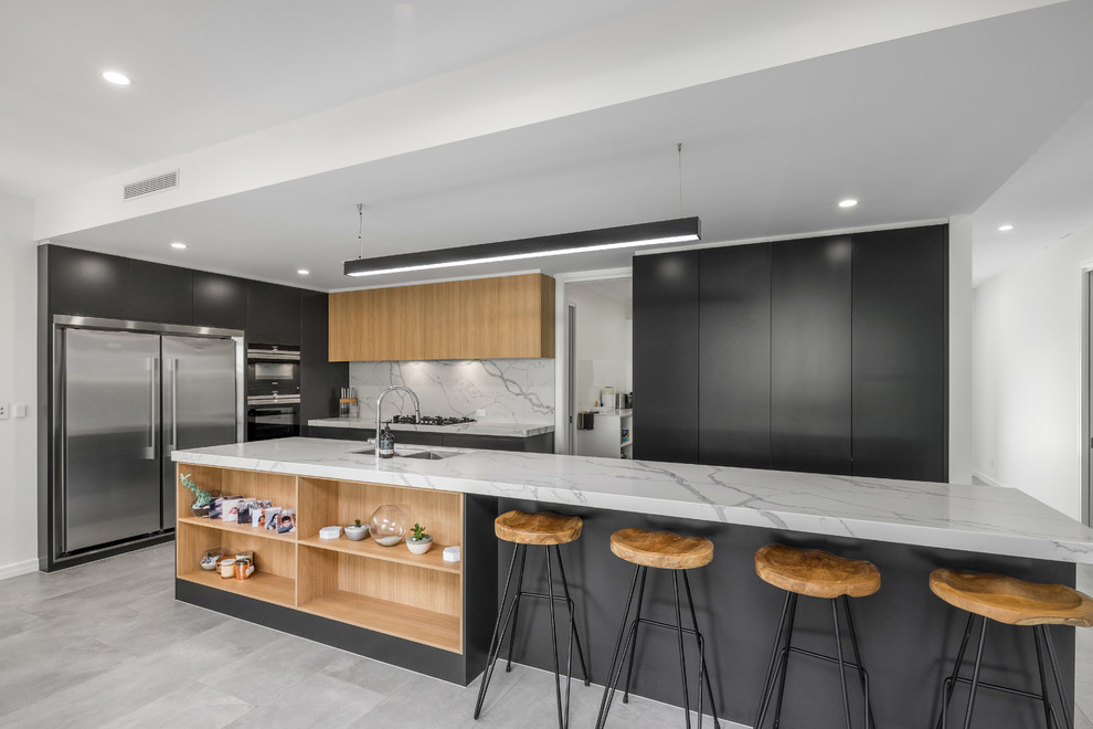 Photo of a large contemporary galley open plan kitchen in Brisbane with flat-panel cabinets, grey cabinets, with island, an undermount sink, quartz benchtops, white splashback, stone slab splashback, stainless steel appliances, porcelain floors and grey floor.