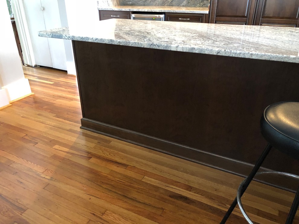 Eat-in kitchen - mid-sized traditional l-shaped light wood floor and brown floor eat-in kitchen idea with an undermount sink, raised-panel cabinets, dark wood cabinets, granite countertops, multicolored backsplash, ceramic backsplash, stainless steel appliances, an island and multicolored countertops