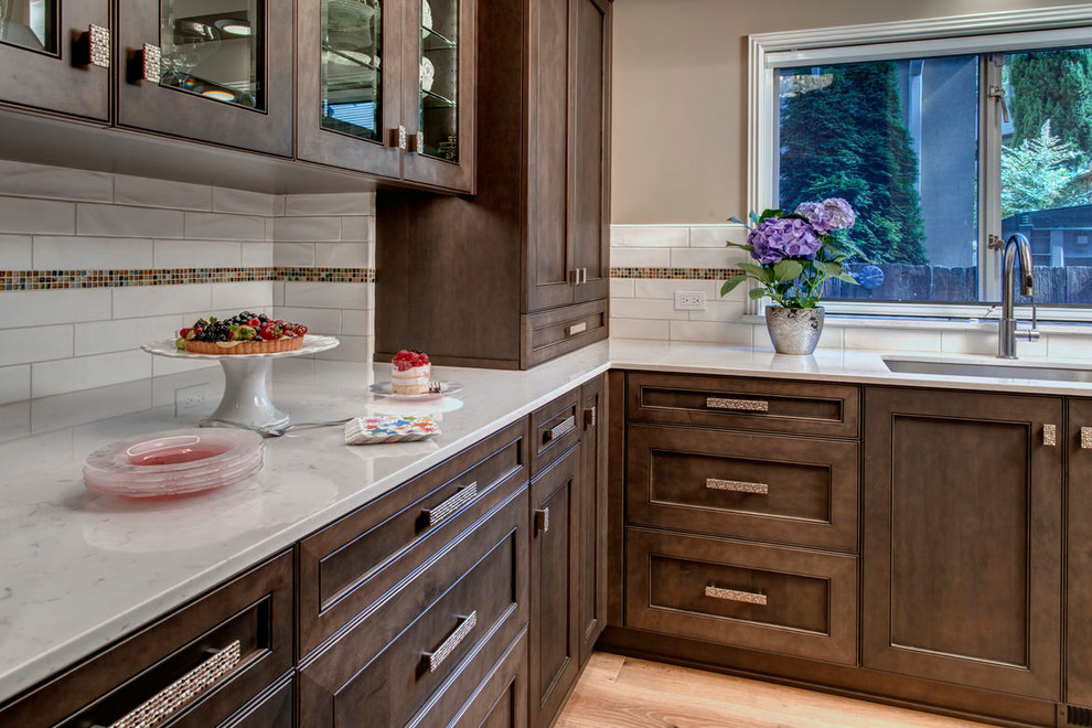 Inspiration for a mid-sized transitional u-shaped open concept kitchen remodel in Seattle with a farmhouse sink, flat-panel cabinets, dark wood cabinets, granite countertops, stainless steel appliances and an island