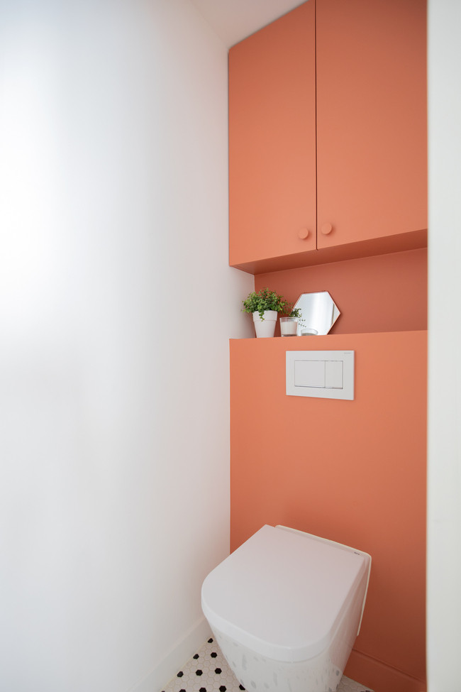 Inspiration pour un WC suspendu design de taille moyenne avec un placard à porte affleurante, des portes de placard oranges, un mur blanc, un sol en carrelage de céramique, un sol multicolore, un plan de toilette blanc et meuble-lavabo suspendu.