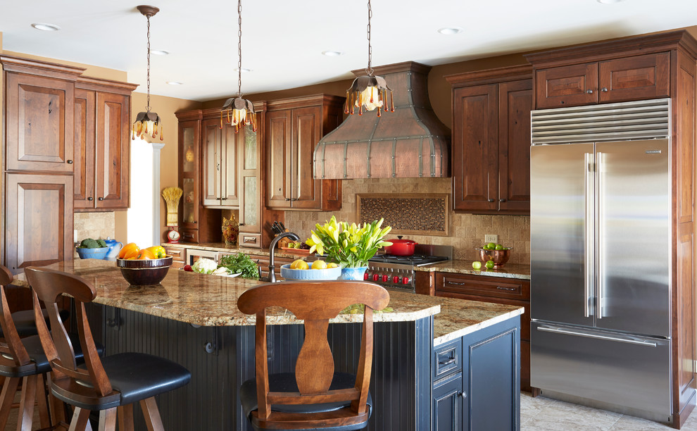 Design ideas for a large country l-shaped eat-in kitchen in Chicago with an undermount sink, raised-panel cabinets, distressed cabinets, granite benchtops, beige splashback, stone tile splashback, stainless steel appliances, porcelain floors and with island.