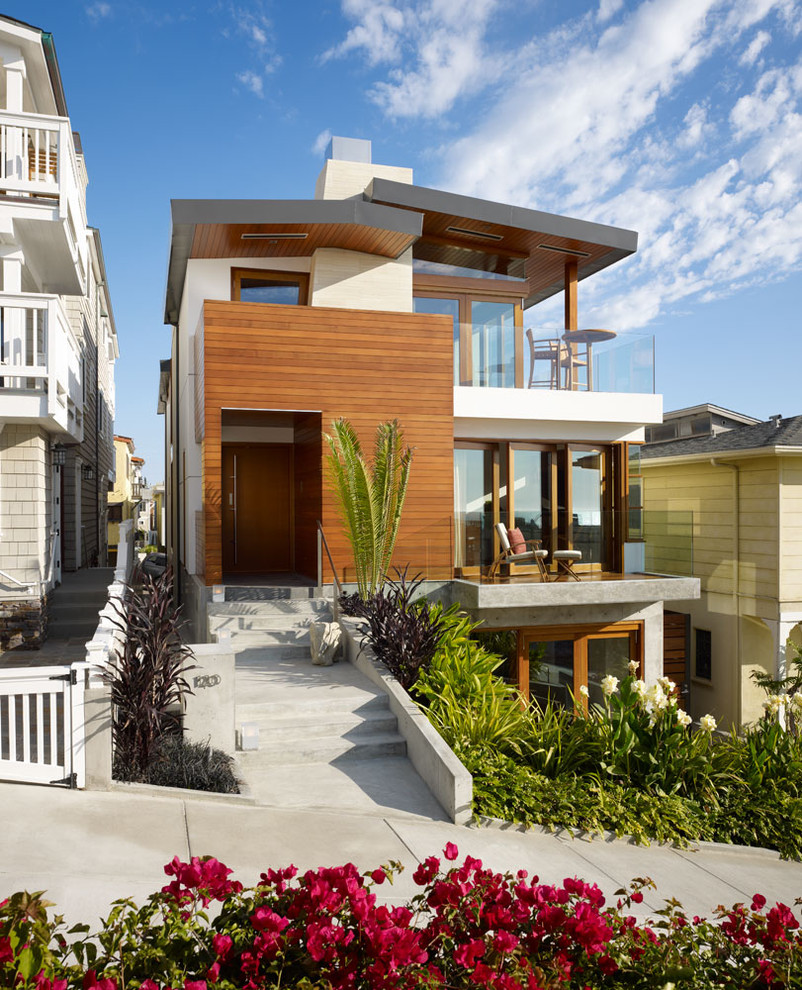 Design ideas for a mid-sized contemporary three-storey house exterior in Los Angeles with wood siding and a metal roof.