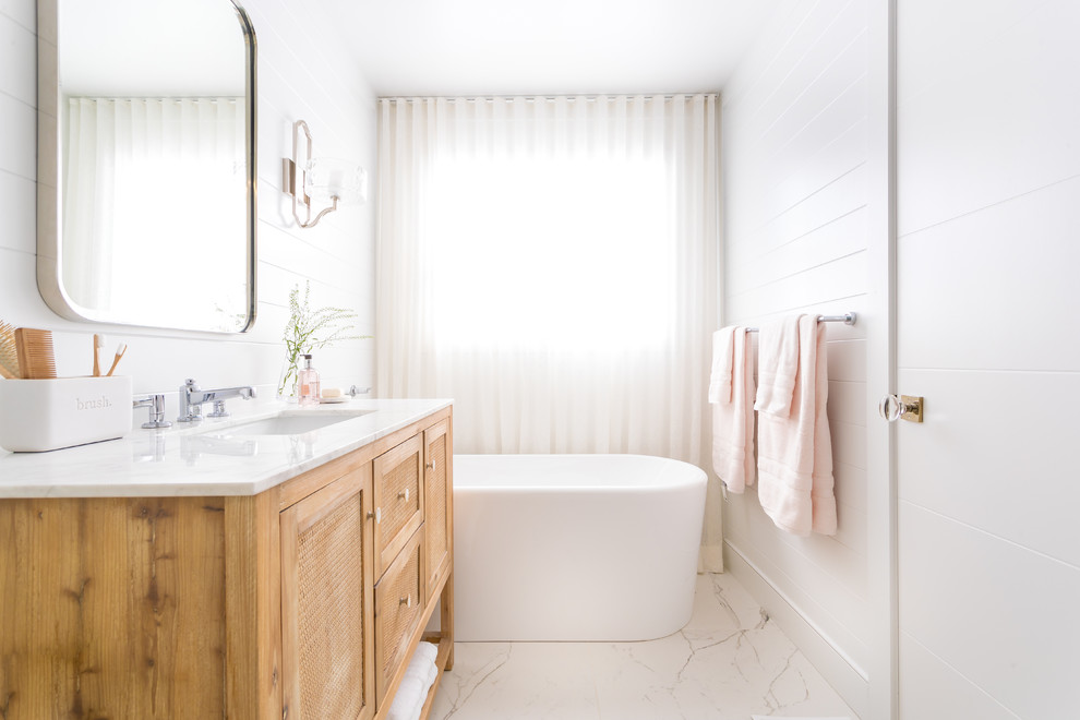 Design ideas for a transitional 3/4 bathroom in Toronto with shaker cabinets, light wood cabinets, a freestanding tub, white walls, an undermount sink and white floor.