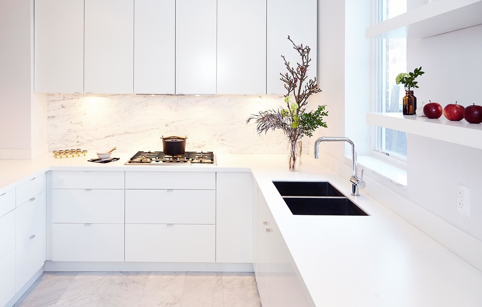 Inspiration for a mid-sized modern u-shaped open plan kitchen in Toronto with an undermount sink, flat-panel cabinets, white cabinets, solid surface benchtops, grey splashback, stone slab splashback, stainless steel appliances and marble floors.