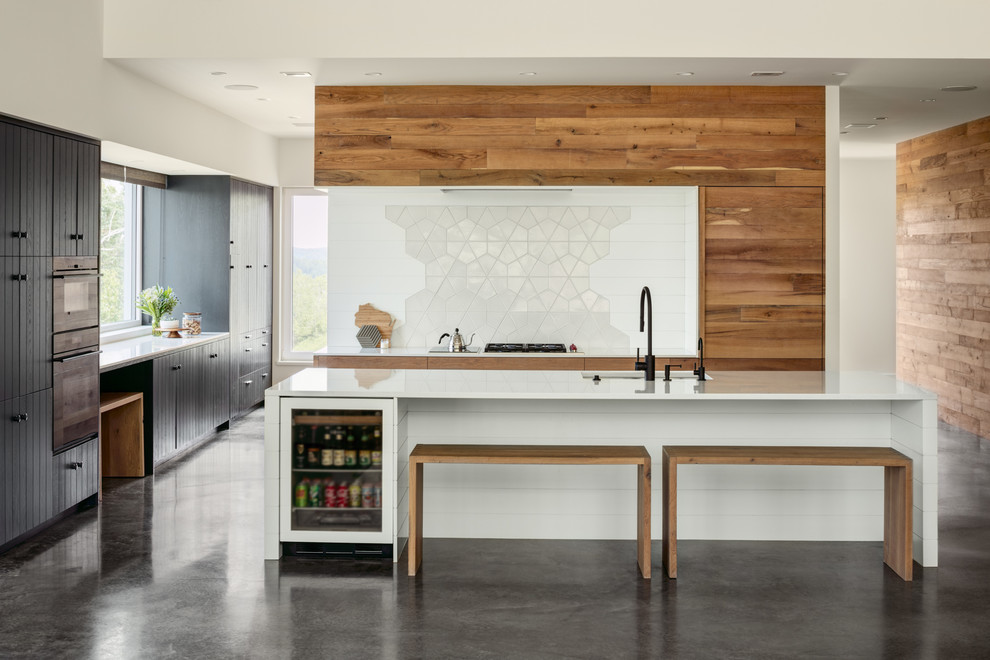 This is an example of a contemporary galley kitchen in Other with beaded inset cabinets, quartz benchtops, white splashback, ceramic splashback, concrete floors, with island, an undermount sink, medium wood cabinets, panelled appliances and grey floor.