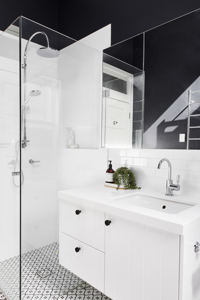 Design ideas for a mid-sized contemporary kids bathroom in Sydney with furniture-like cabinets, white cabinets, an open shower, white tile, porcelain tile, porcelain floors, an undermount sink, engineered quartz benchtops, a hinged shower door and grey benchtops.