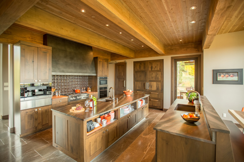 Photo of a country kitchen in Denver with an undermount sink, recessed-panel cabinets, dark wood cabinets, metallic splashback, panelled appliances and with island.