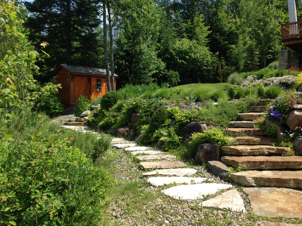 Photo of a country sloped full sun xeriscape for summer in Montreal with natural stone pavers.