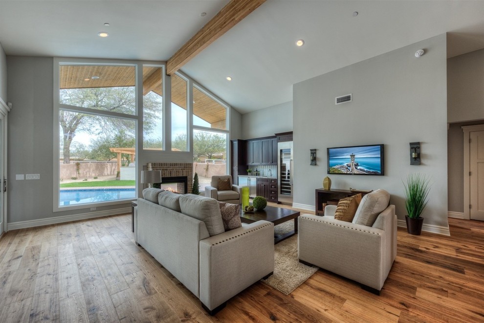 Large transitional open concept family room in Phoenix with grey walls and medium hardwood floors.
