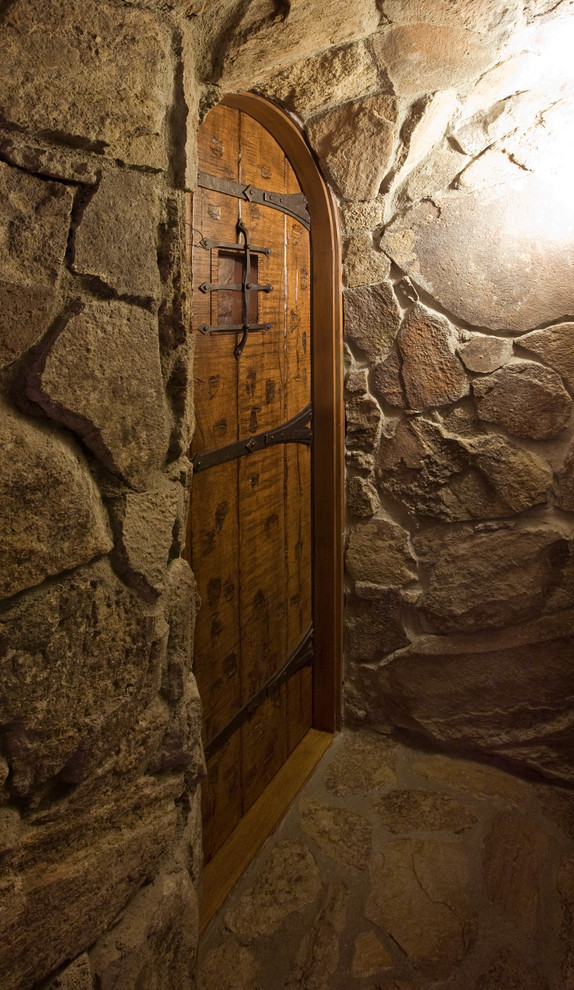 Mid-sized mountain style limestone floor and brown floor wine cellar photo in Phoenix with storage racks