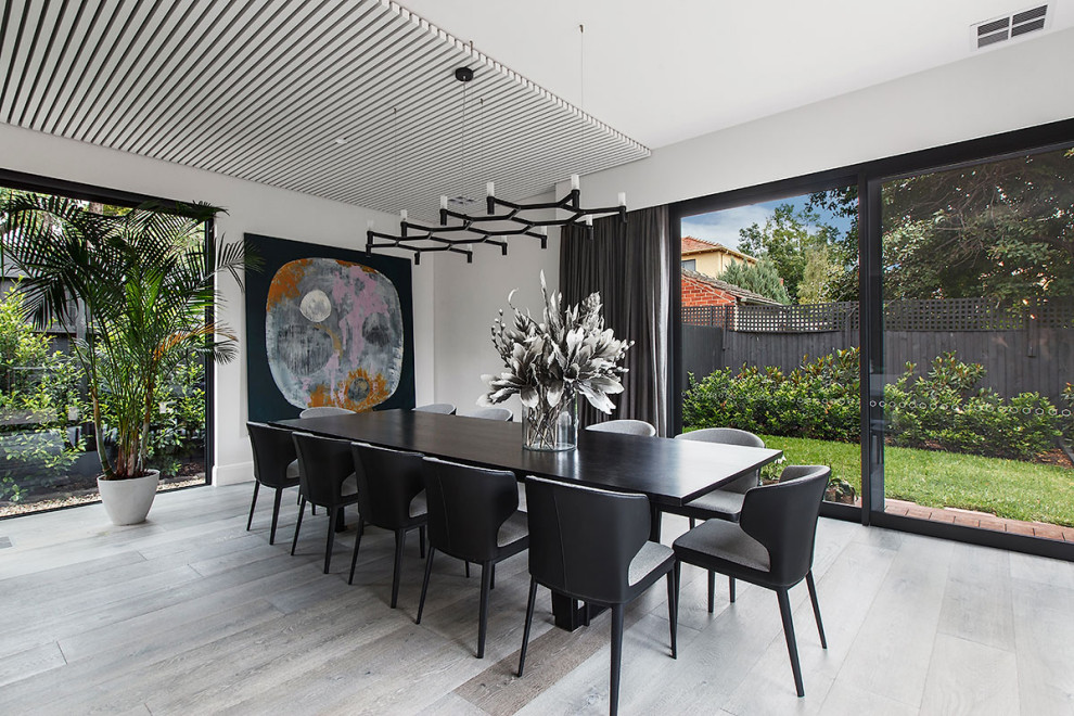 Inspiration for a large contemporary dining room in Melbourne with white walls and grey floor.