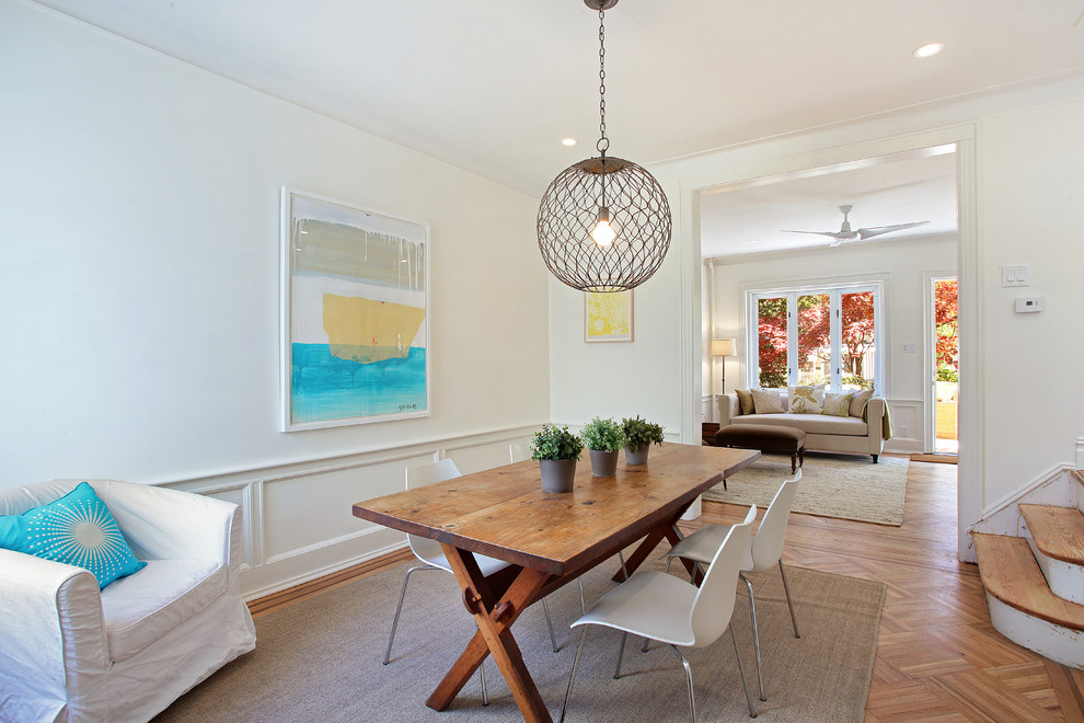 This is an example of a mid-sized contemporary separate dining room in New York with white walls and medium hardwood floors.