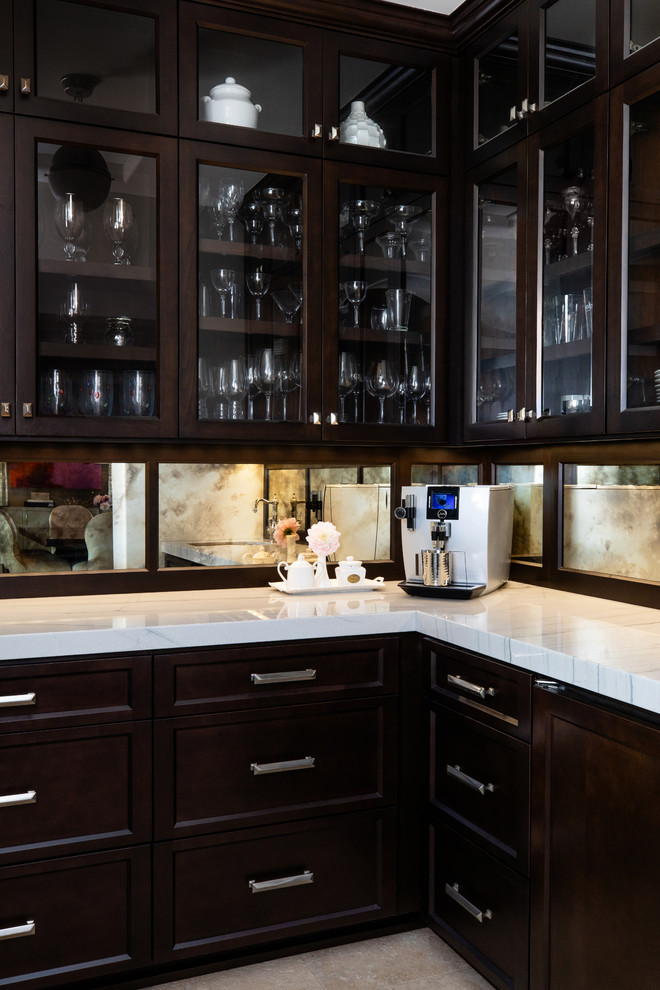 Photo of a large transitional u-shaped kitchen pantry in San Diego with an undermount sink, beaded inset cabinets, dark wood cabinets, quartzite benchtops, white splashback, marble splashback, stainless steel appliances, travertine floors, with island, beige floor and white benchtop.