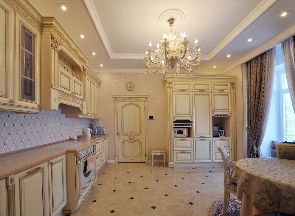 This is an example of a traditional eat-in kitchen in Yekaterinburg with raised-panel cabinets, beige cabinets, white splashback and no island.