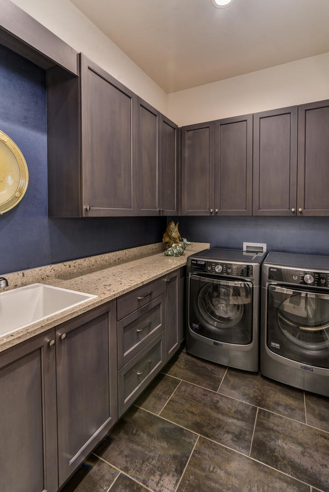 This is an example of a small country galley dedicated laundry room in Los Angeles with a drop-in sink, recessed-panel cabinets, dark wood cabinets, quartz benchtops, blue walls and a side-by-side washer and dryer.