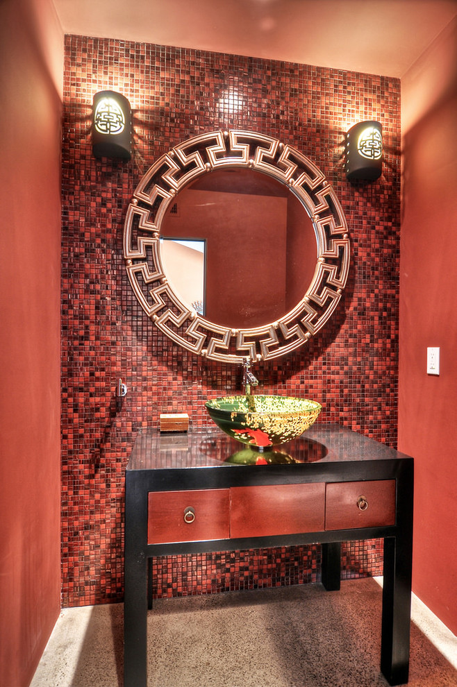 Mid-sized asian powder room in Orange County with a vessel sink, red tile, red walls, furniture-like cabinets, red cabinets, concrete floors and mosaic tile.