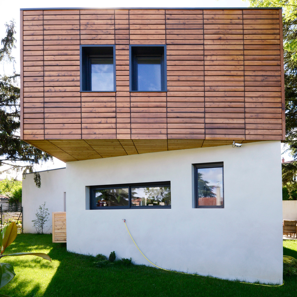 This is an example of a mid-sized contemporary two-storey exterior in Lyon with mixed siding.