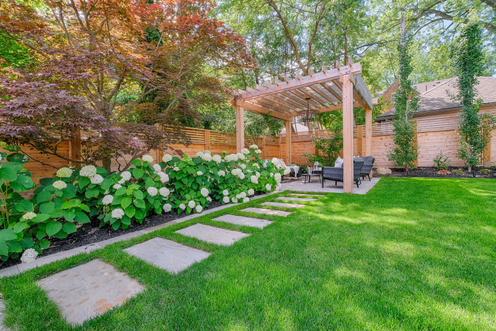 Idee per un grande giardino tradizionale esposto in pieno sole dietro casa in estate con pavimentazioni in pietra naturale e recinzione in legno