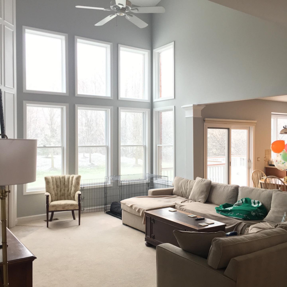 Photo of a mid-sized modern open concept living room in Detroit with white walls, carpet, a standard fireplace, a tile fireplace surround, beige floor, vaulted and decorative wall panelling.