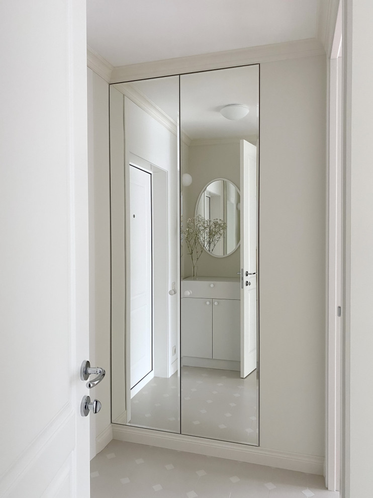 Immagine di un piccolo corridoio design con pareti beige, pavimento in gres porcellanato, una porta singola, una porta bianca e pavimento beige