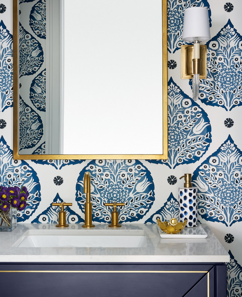 Klassisk inredning av ett litet vit vitt toalett, med möbel-liknande, blå skåp, blå väggar, mörkt trägolv, ett undermonterad handfat, bänkskiva i kvarts och brunt golv