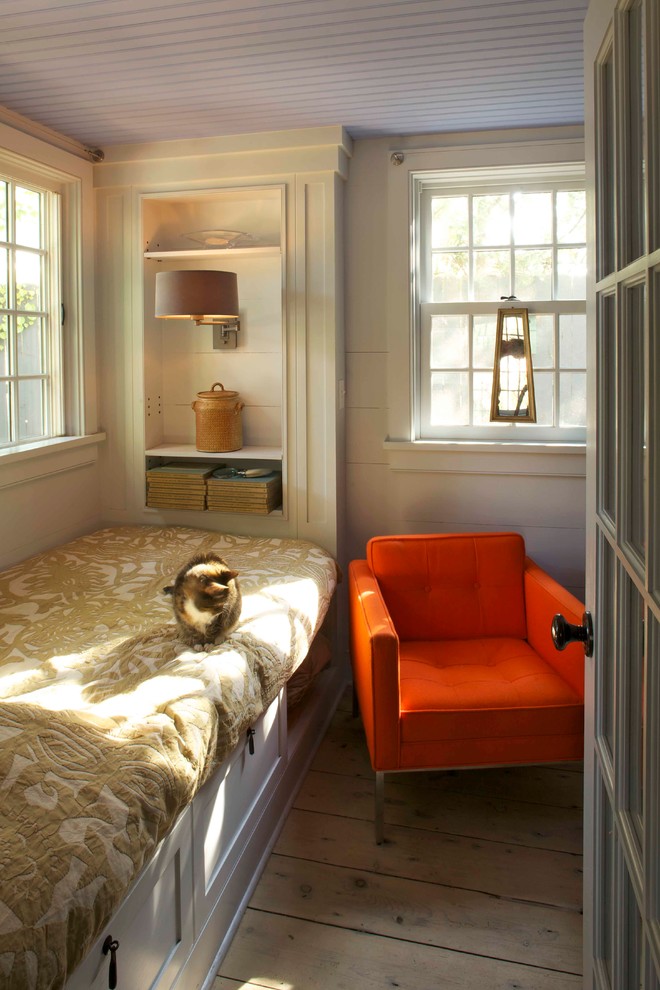 Design ideas for a country bedroom in New York with beige walls and light hardwood floors.
