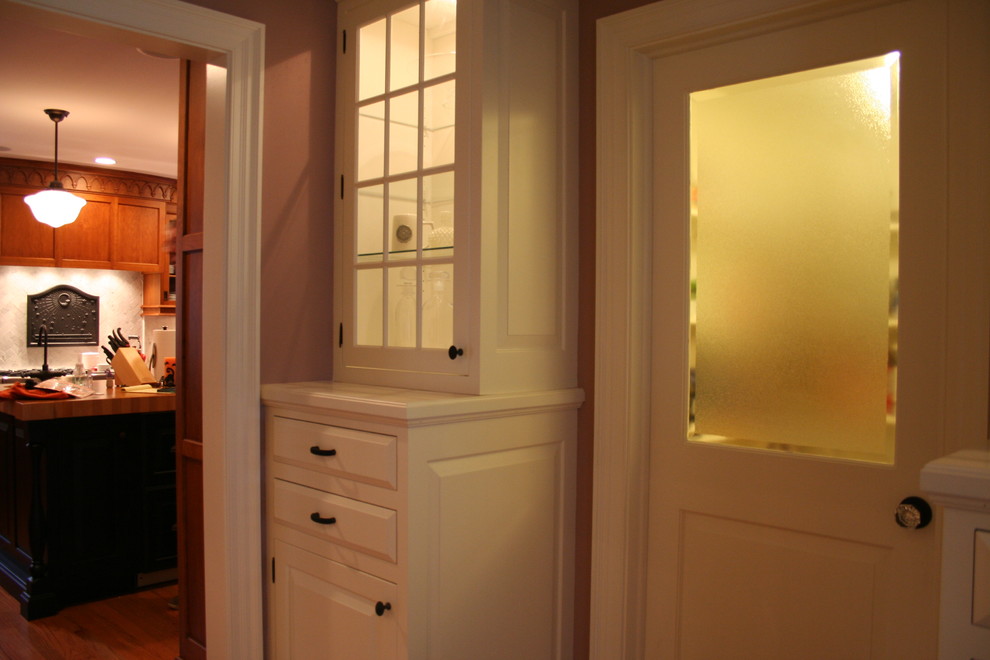 This is an example of a traditional hallway in New York with brown walls and medium hardwood floors.