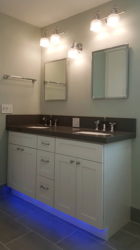 Example of a mid-sized transitional master gray tile and marble tile porcelain tile corner shower design in Miami with shaker cabinets, white cabinets, a two-piece toilet, green walls, an undermount sink and quartz countertops