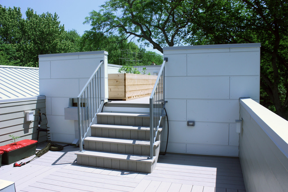Photo of a mid-sized midcentury split-level white exterior in Chicago with concrete fiberboard siding.