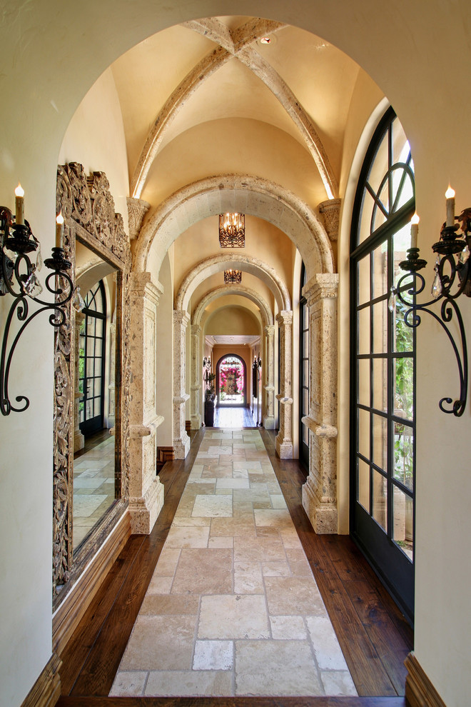Inspiration for an expansive mediterranean hallway in Phoenix with beige walls and travertine floors.