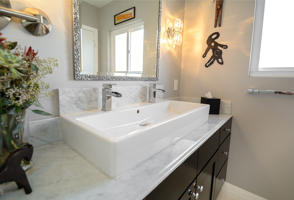Inspiration for a mid-sized transitional bathroom in Los Angeles with black cabinets, white walls, a trough sink, marble benchtops, flat-panel cabinets, beige tile and mosaic tile floors.