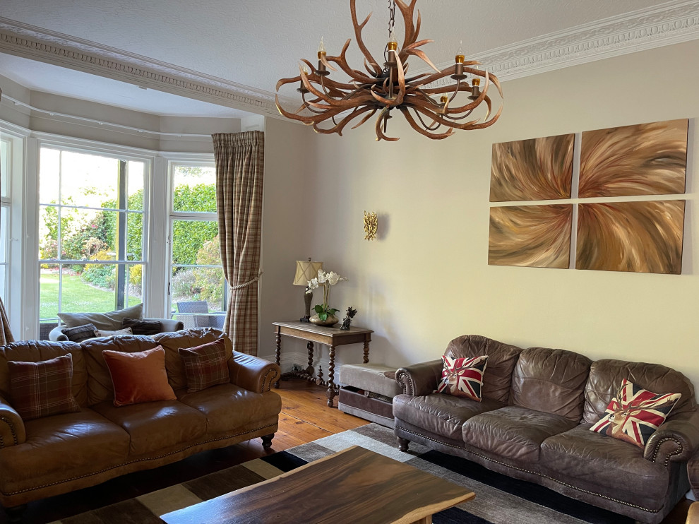 Ejemplo de salón cerrado tradicional de tamaño medio con suelo de madera en tonos medios, estufa de leña, televisor colgado en la pared, papel pintado y papel pintado