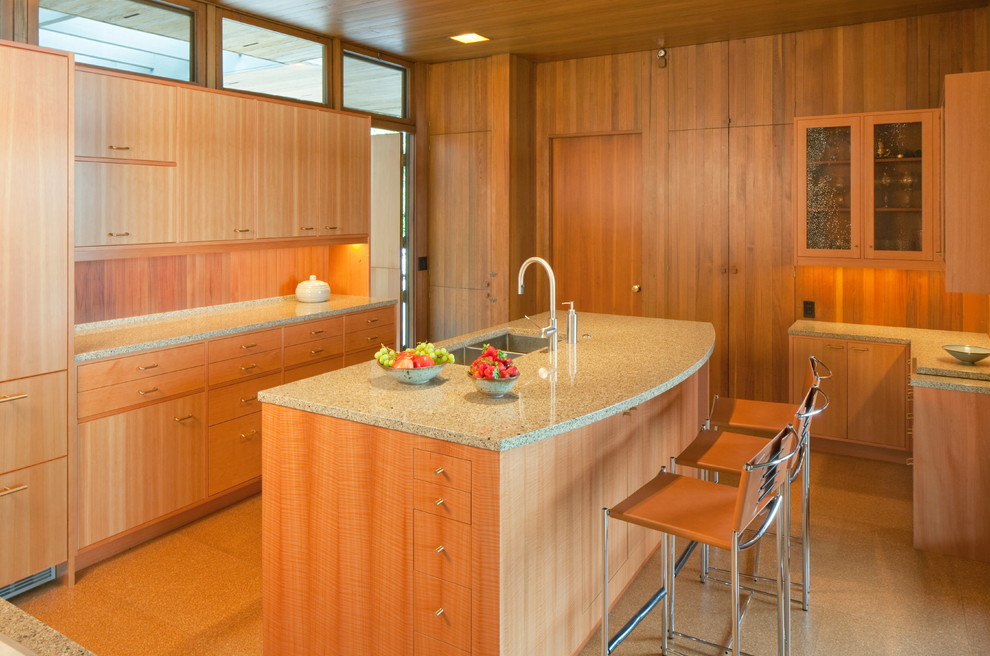 Design ideas for a mid-sized midcentury separate kitchen in Portland with with island, flat-panel cabinets, medium wood cabinets, granite benchtops, grey splashback, stone tile splashback, panelled appliances, a double-bowl sink and cork floors.