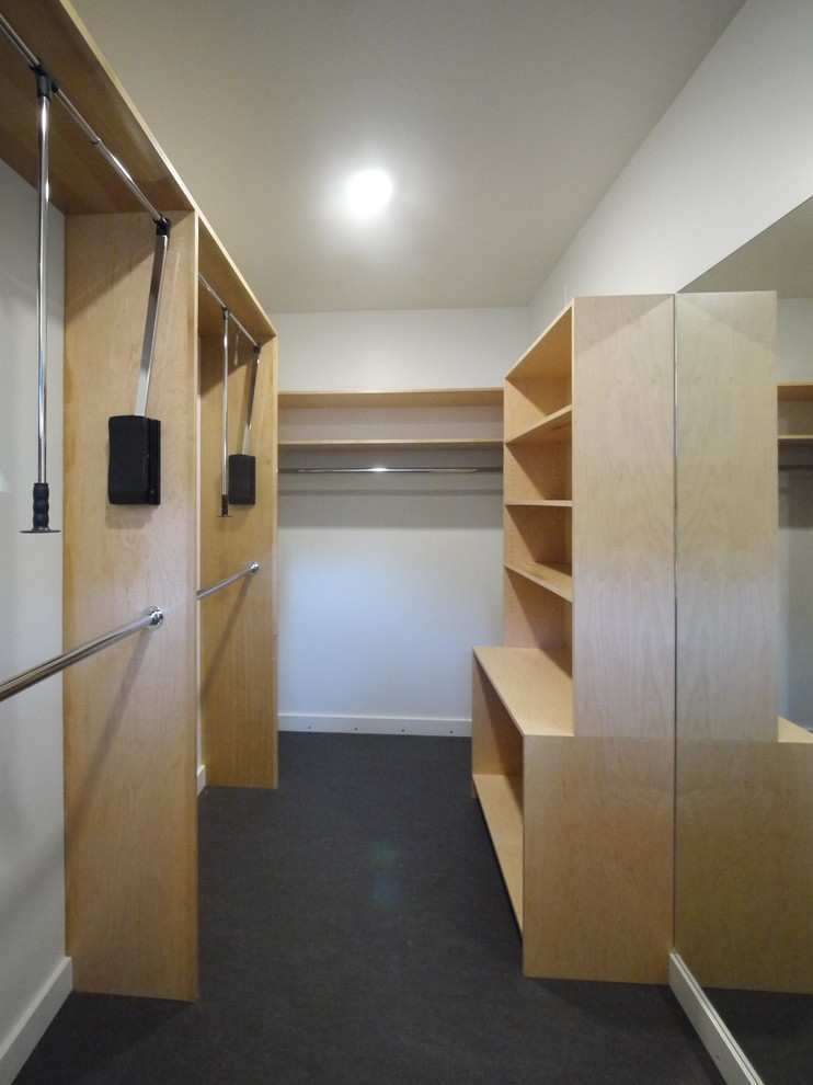 This is an example of a large modern men's dressing room in Houston with flat-panel cabinets, light wood cabinets, linoleum floors and grey floor.