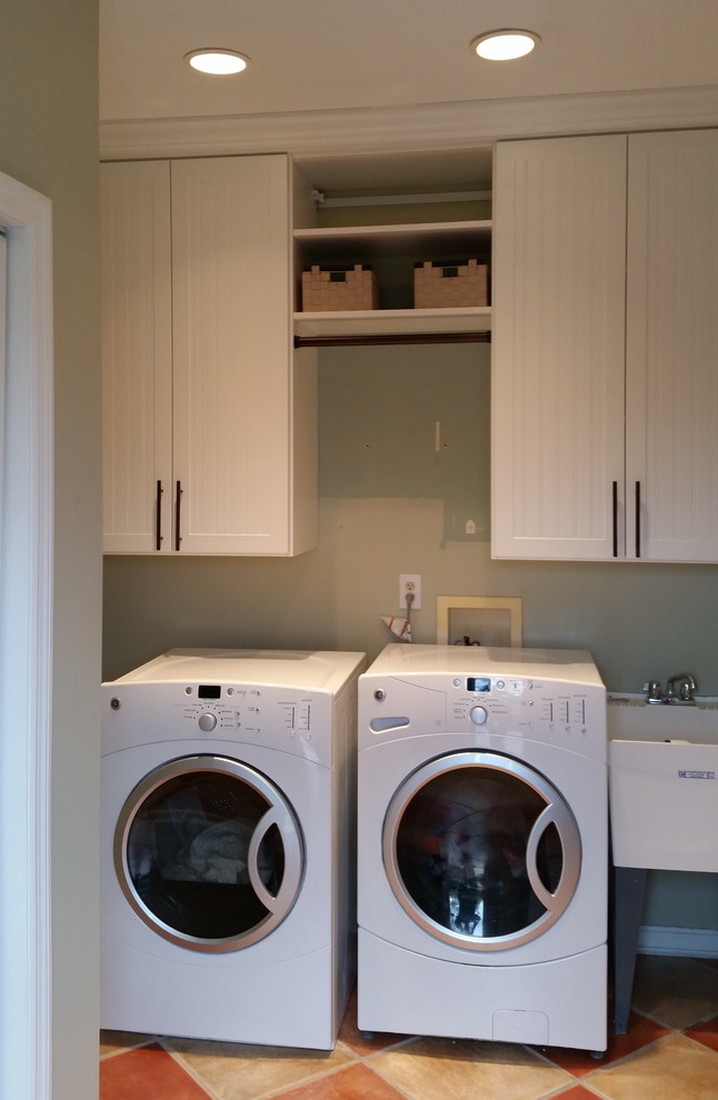 Mid-sized country utility room in Cincinnati with an utility sink, beaded inset cabinets, white cabinets, porcelain floors and a side-by-side washer and dryer.