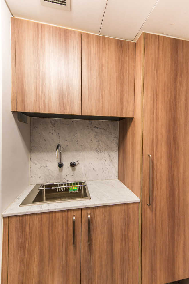 Photo of a contemporary utility room in Sydney with granite worktops and grey splashback.