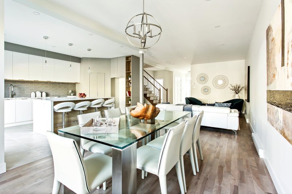 Large contemporary kitchen/dining combo in Montreal with white walls, medium hardwood floors and brown floor.