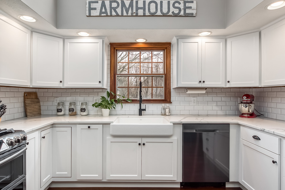 Large transitional u-shaped eat-in kitchen photo in Columbus with shaker cabinets, quartz countertops, white backsplash and an island