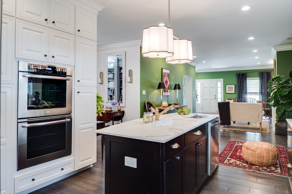 Inspiration for a large transitional u-shaped medium tone wood floor and brown floor eat-in kitchen remodel in Indianapolis with an undermount sink, raised-panel cabinets, white cabinets, marble countertops, white backsplash, subway tile backsplash, stainless steel appliances, an island and white countertops
