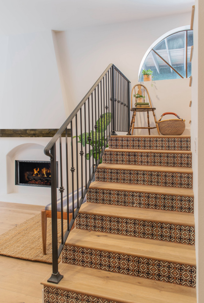 Modelo de escalera mediterránea con escalones de madera, contrahuellas de terracota y barandilla de metal