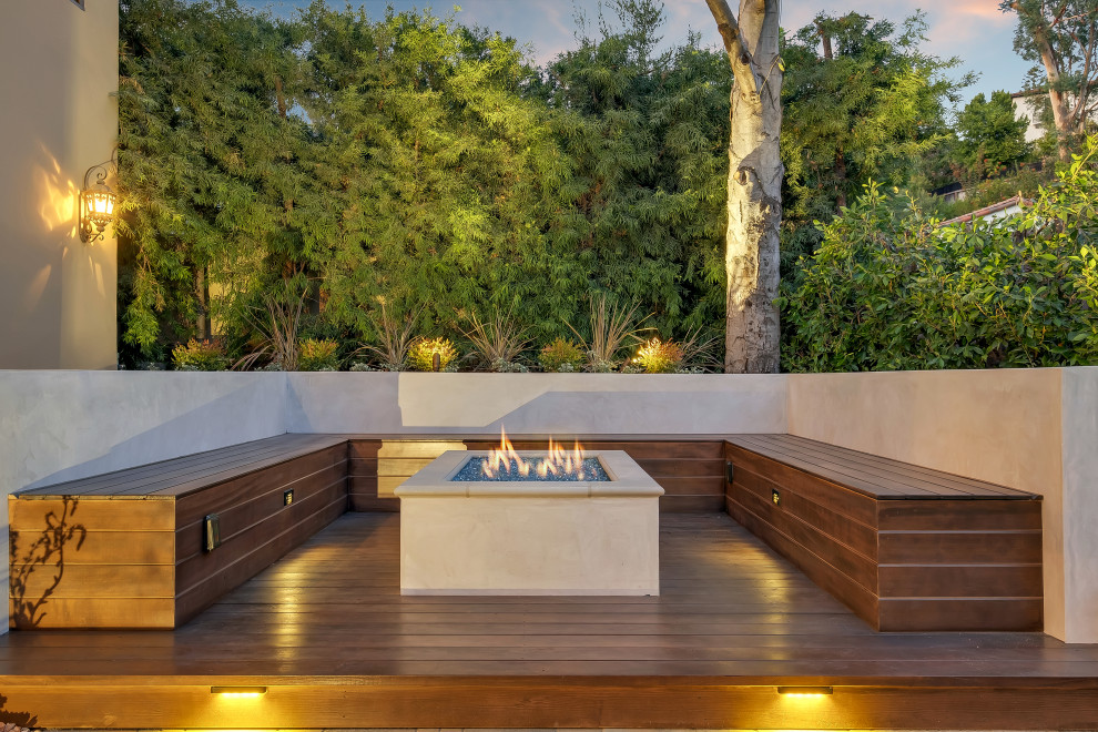 Example of a mid-sized trendy backyard deck design in Los Angeles with a fire pit and no cover
