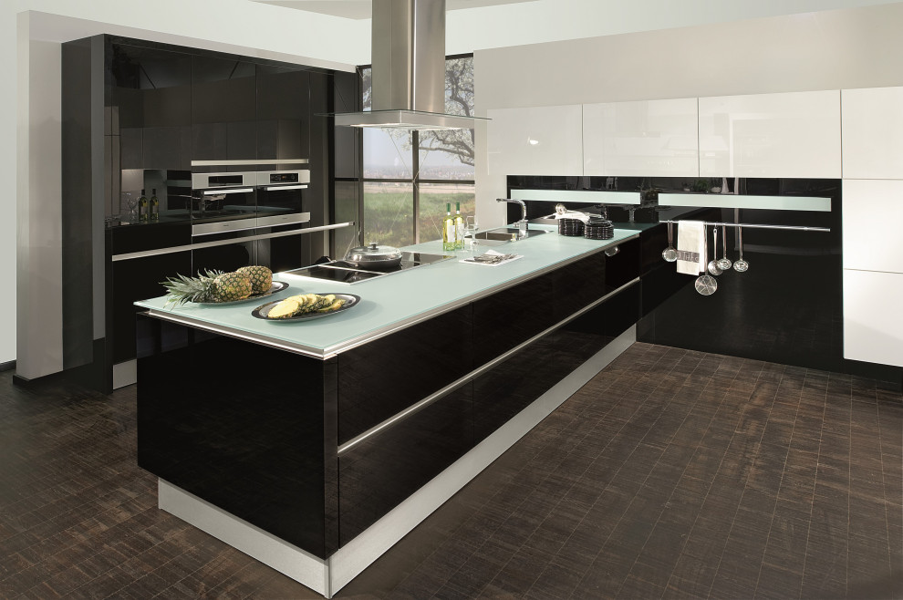 Mid-sized modern l-shaped eat-in kitchen in Vancouver with a drop-in sink, flat-panel cabinets, black cabinets, glass benchtops, black splashback, glass sheet splashback, stainless steel appliances, porcelain floors, a peninsula, brown floor and green benchtop.