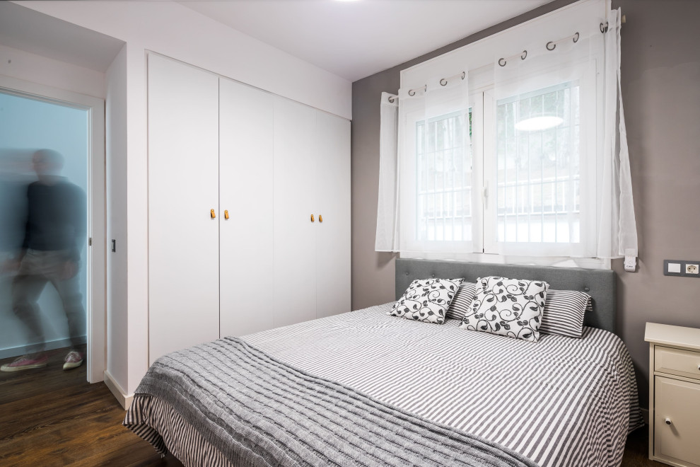 Ejemplo de dormitorio principal y gris y blanco mediterráneo de tamaño medio con paredes grises, suelo de madera oscura y suelo marrón