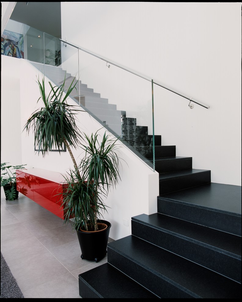 Idée de décoration pour un grand escalier carrelé droit design avec des contremarches carrelées.