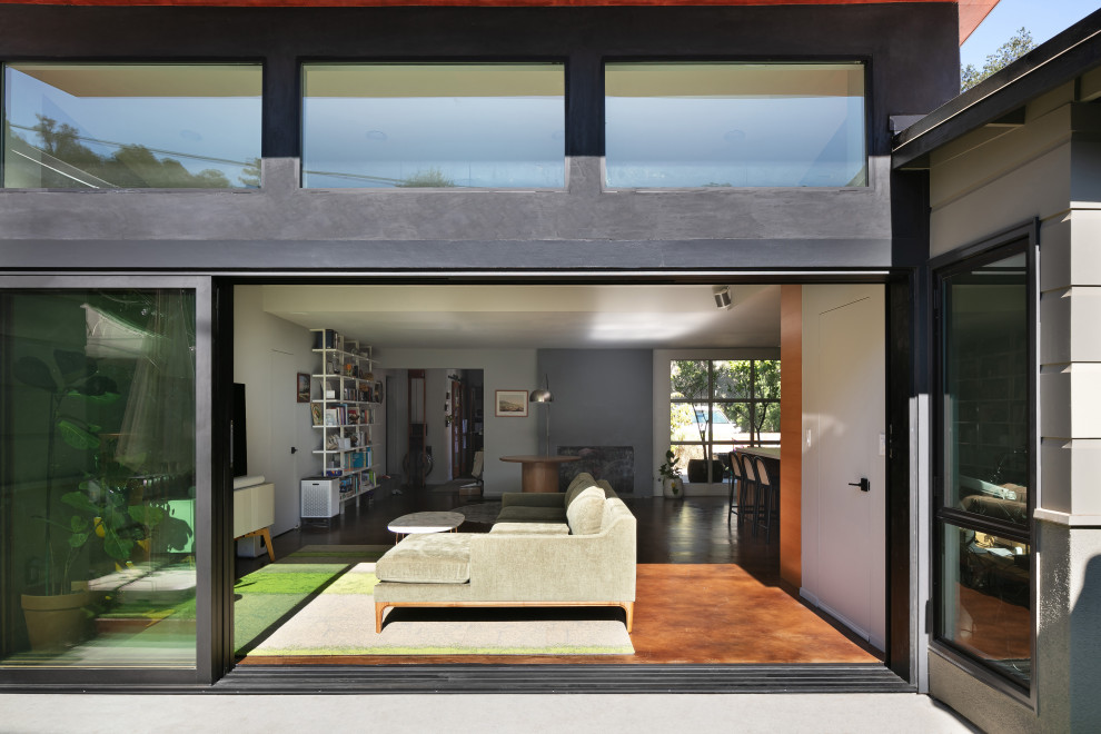 Bild på ett mellanstort 50 tals allrum med öppen planlösning, med grå väggar, betonggolv, en fristående TV och brunt golv