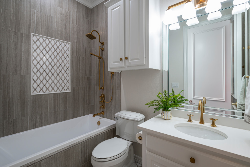 Klassisches Badezimmer mit weißen Schränken, Duschbadewanne, grauen Fliesen, Duschvorhang-Duschabtrennung, weißer Waschtischplatte, Einzelwaschbecken und eingebautem Waschtisch in Dallas