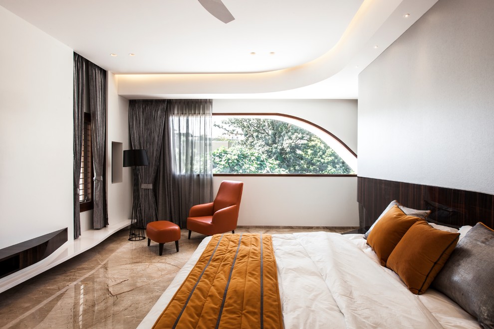 This is an example of a contemporary bedroom in Bengaluru with white walls and brown floor.