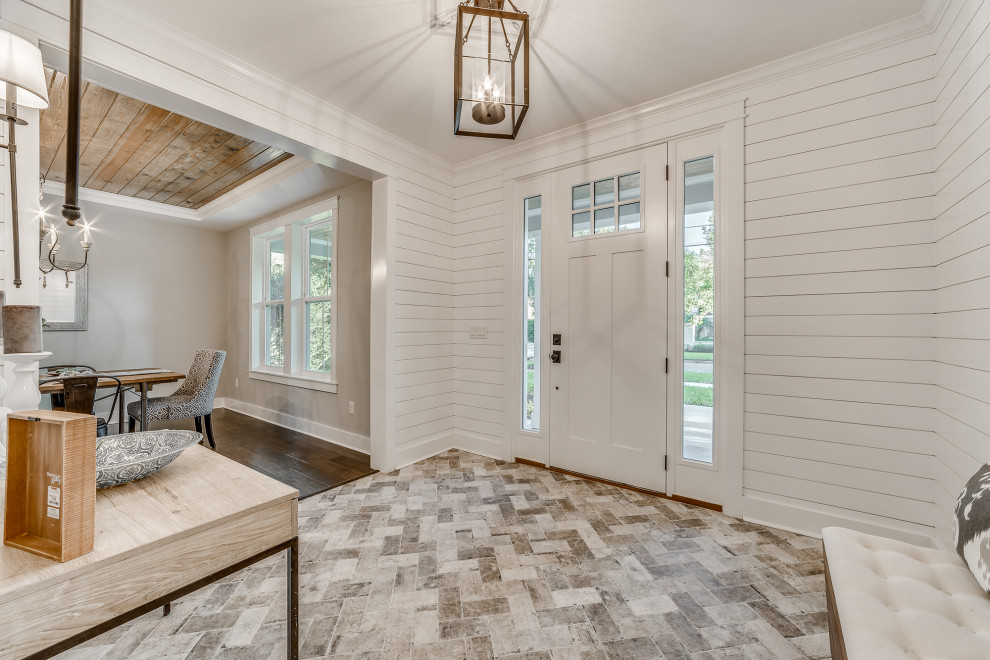 Photo of a mid-sized country foyer in Jacksonville with white walls, porcelain floors, a single front door, a white front door and beige floor.